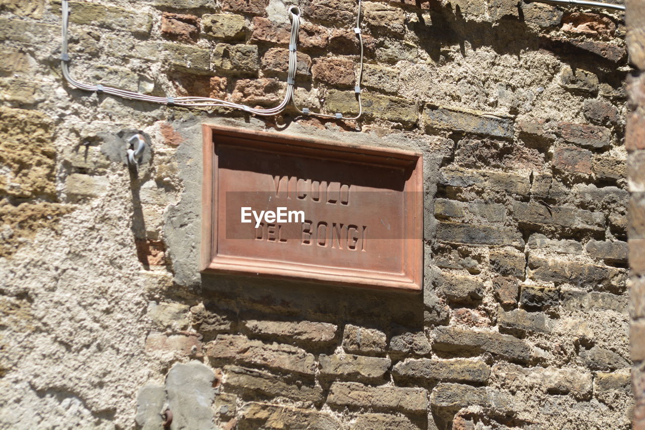 CLOSE-UP OF SIGN BOARD ON WALL