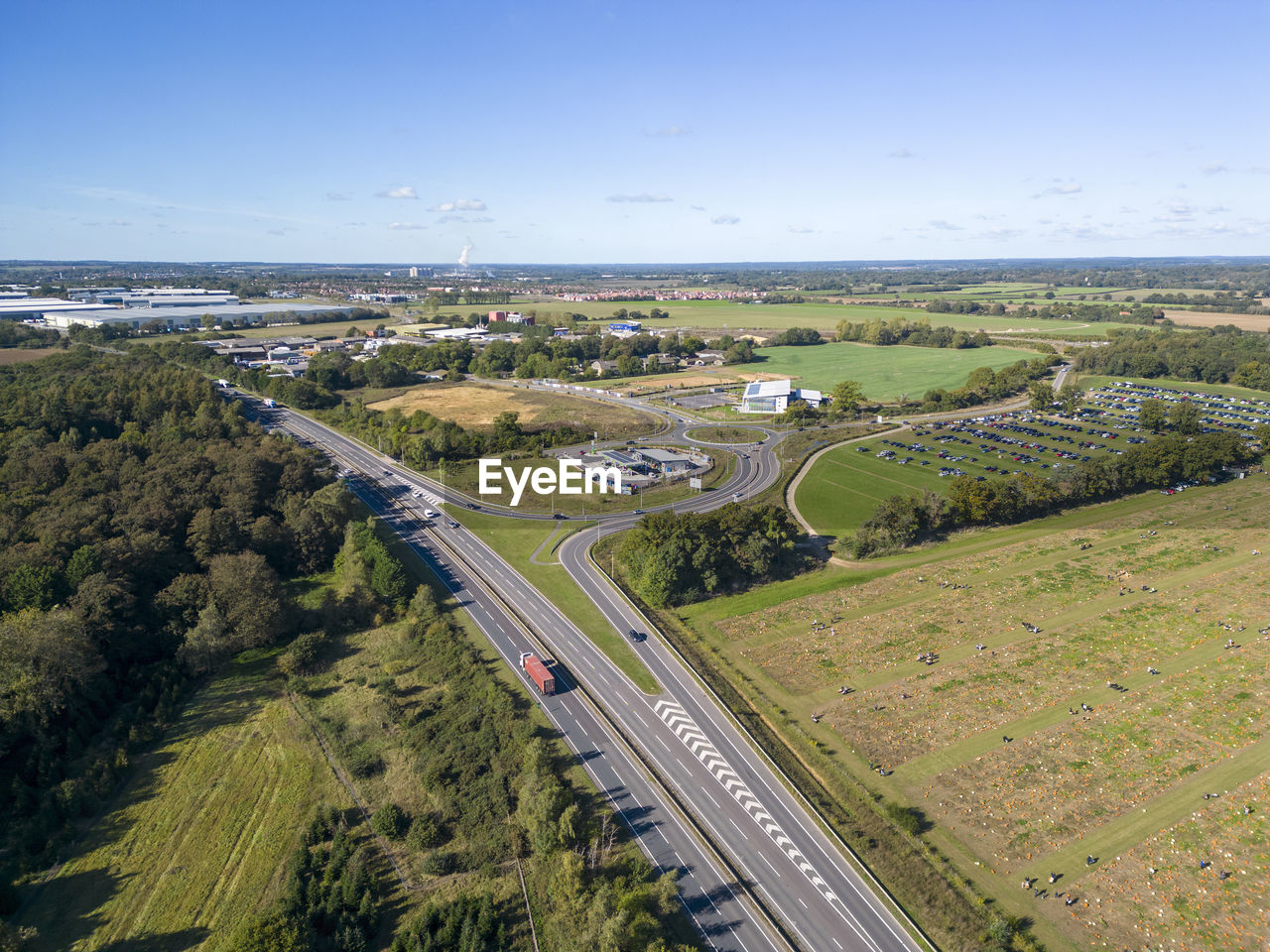 aerial photography, landscape, environment, transportation, road, sky, nature, land, high angle view, scenics - nature, aerial view, plant, highway, architecture, city, travel, built structure, mode of transportation, no people, water, tree, day, outdoors, beauty in nature, travel destinations, field, horizon, rural scene, freeway, motor vehicle, building exterior, car, sea, tourism, building, plain, green, street, blue, agriculture, sunny, sunlight, tranquility, tranquil scene, bird's-eye view, cloud, rural area, transport, hill, infrastructure, clear sky