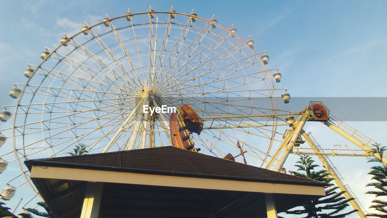 LOW ANGLE VIEW OF FERRIS WHEEL IN AMUSEMENT PARK