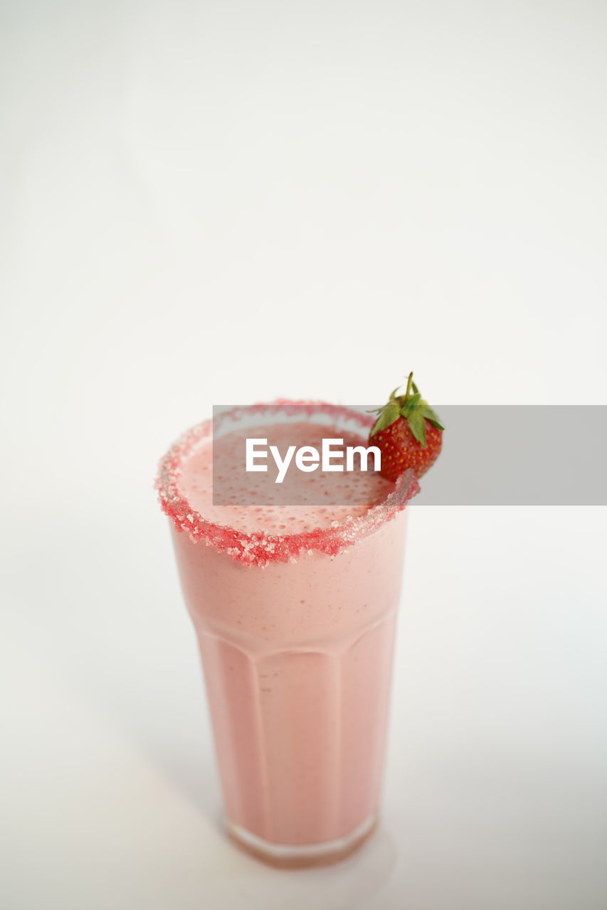 CLOSE-UP OF RED FRUIT ON WHITE BACKGROUND