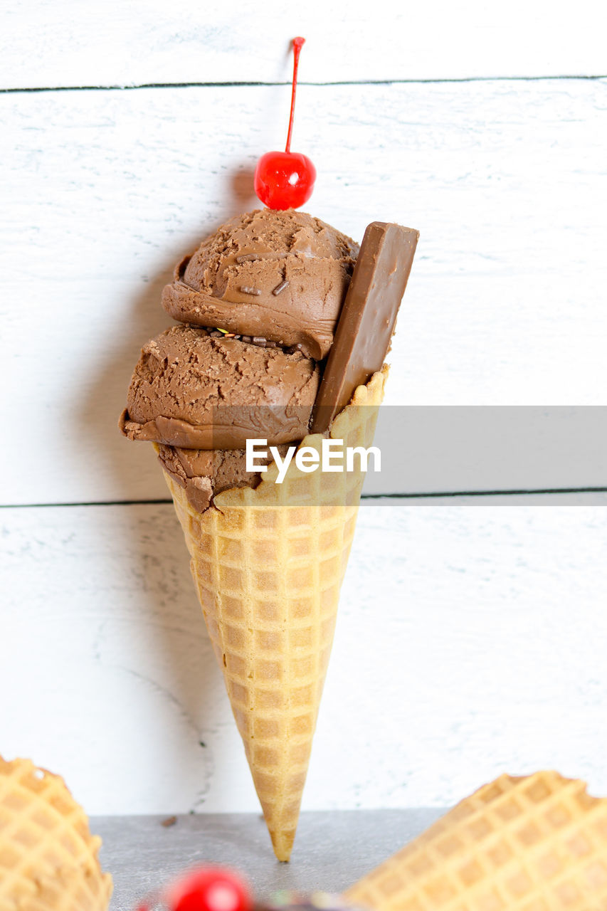 Chocolate ice cream waffle cone with cherry on top