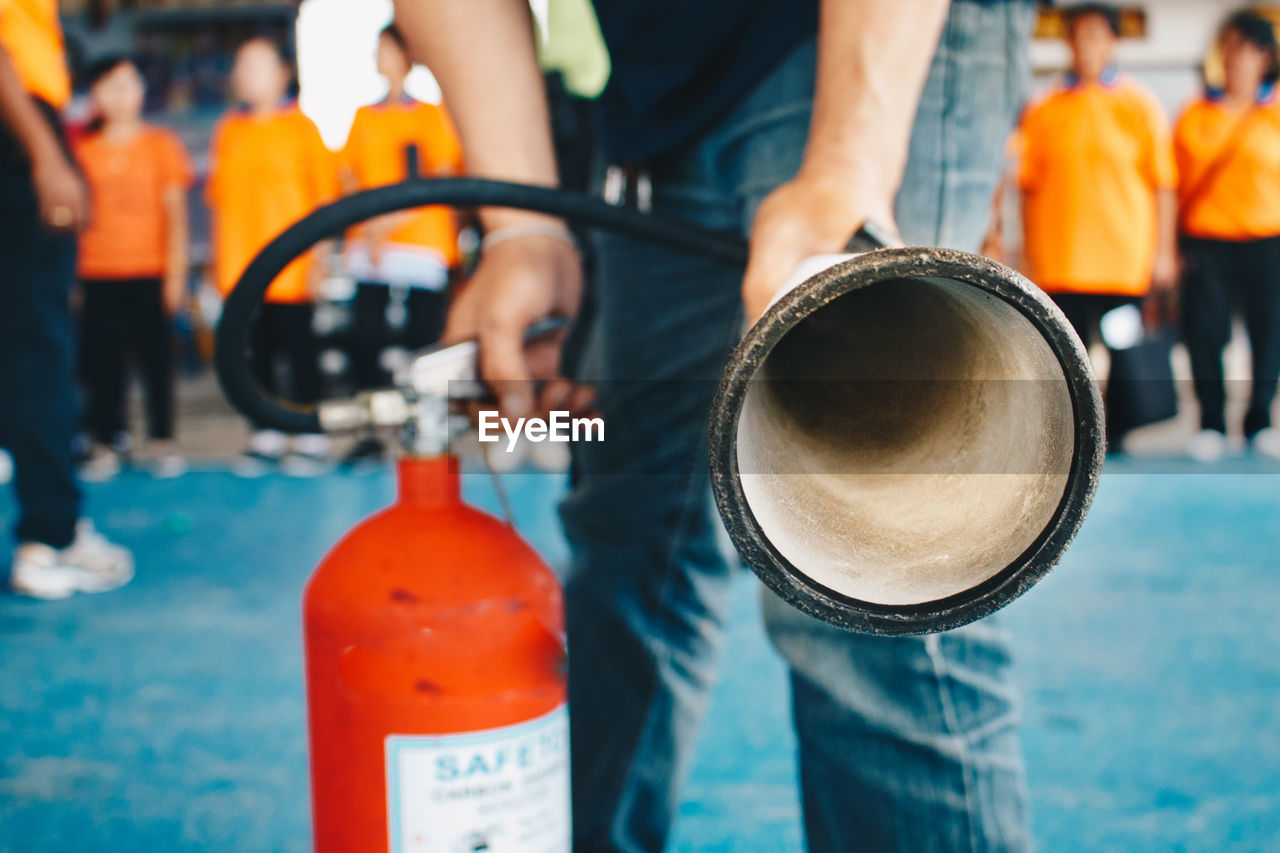 Close-up of firefighter holding fire extinguisher