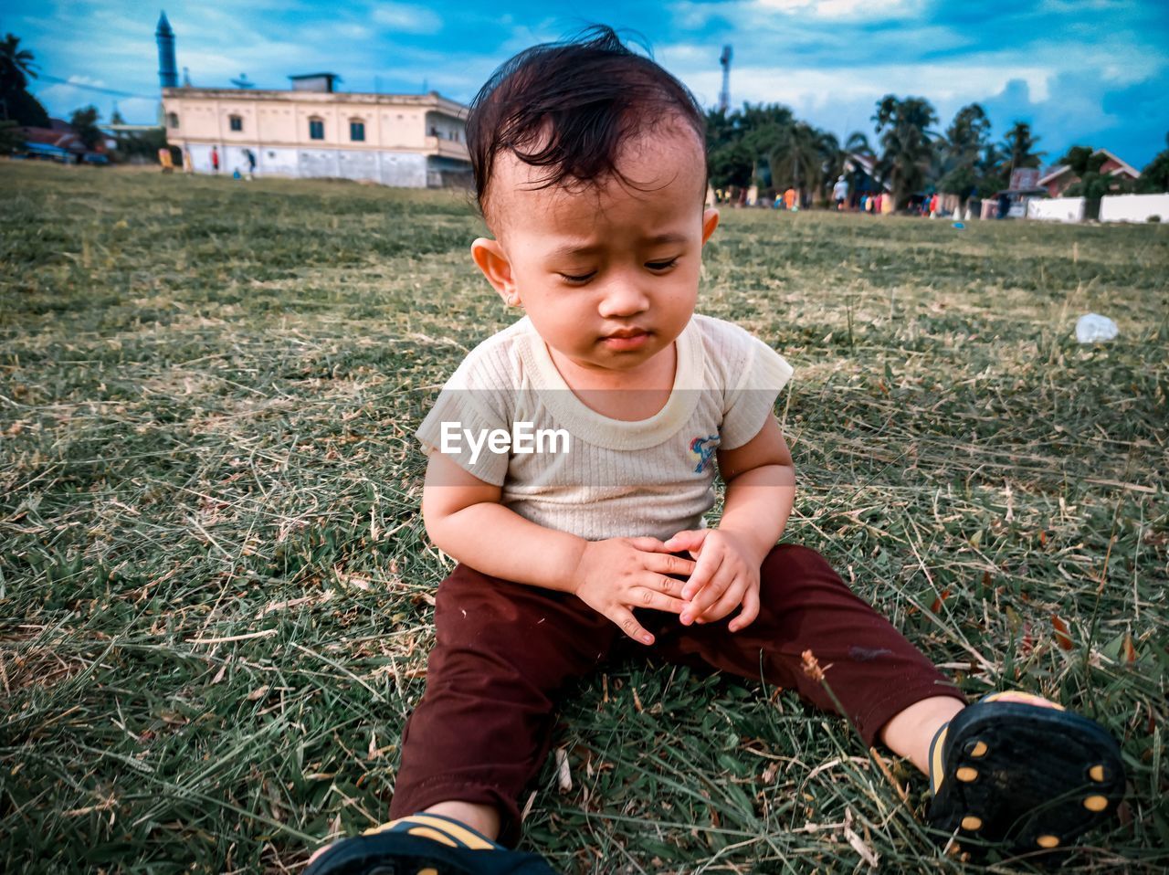 Cute child sitting on field