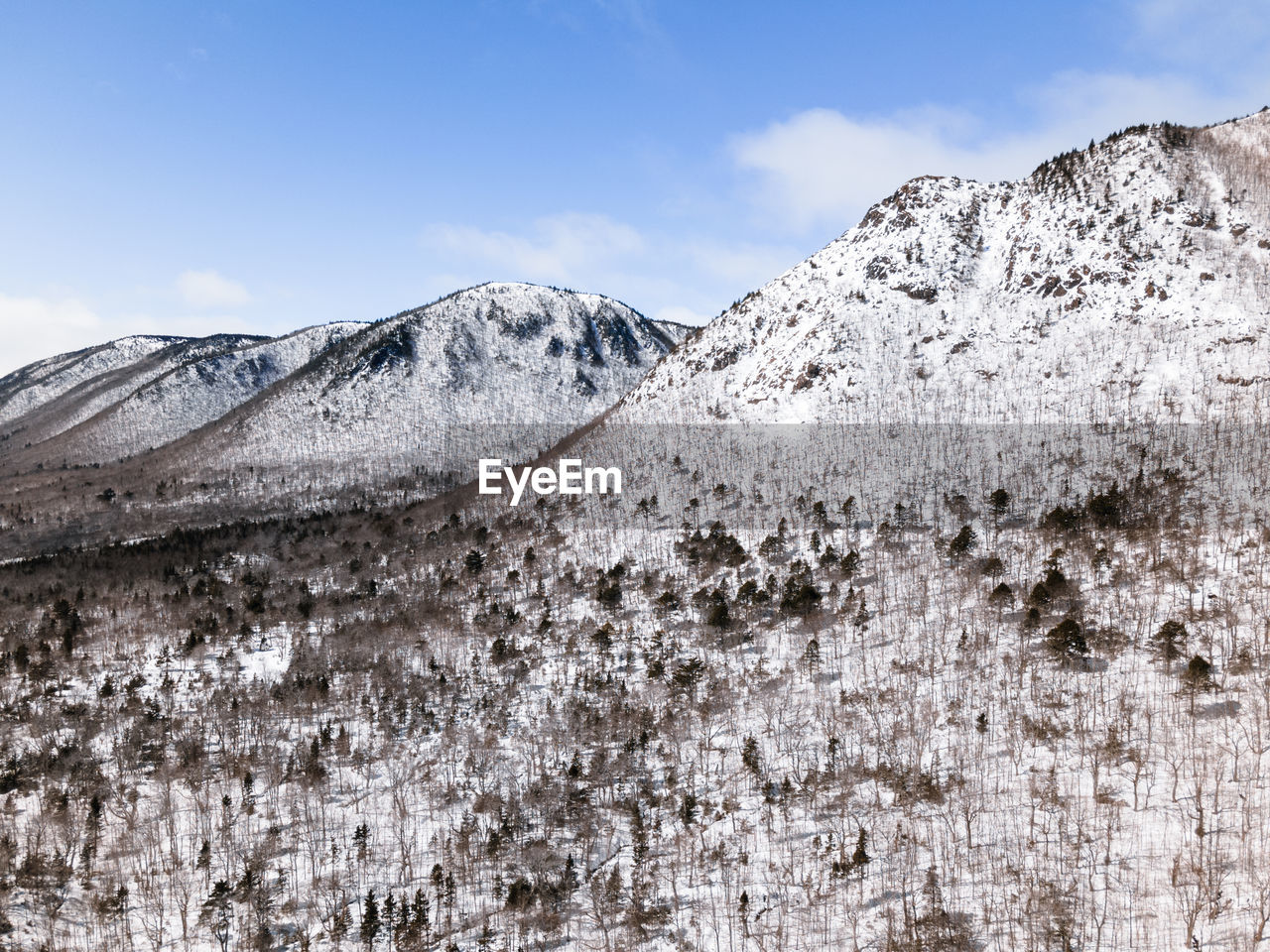 Scenic view of snowcapped mountains against blue sky