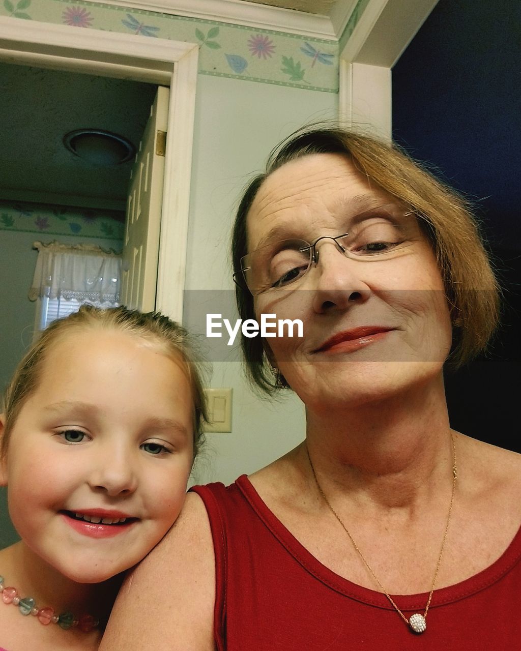 Portrait of happy grandmother and granddaughter at home