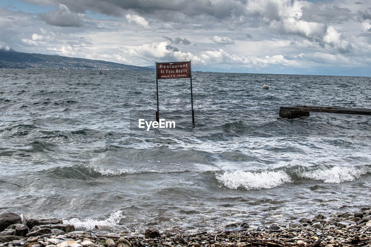 LIFEGUARD HUT IN SEA AGAINST SKY