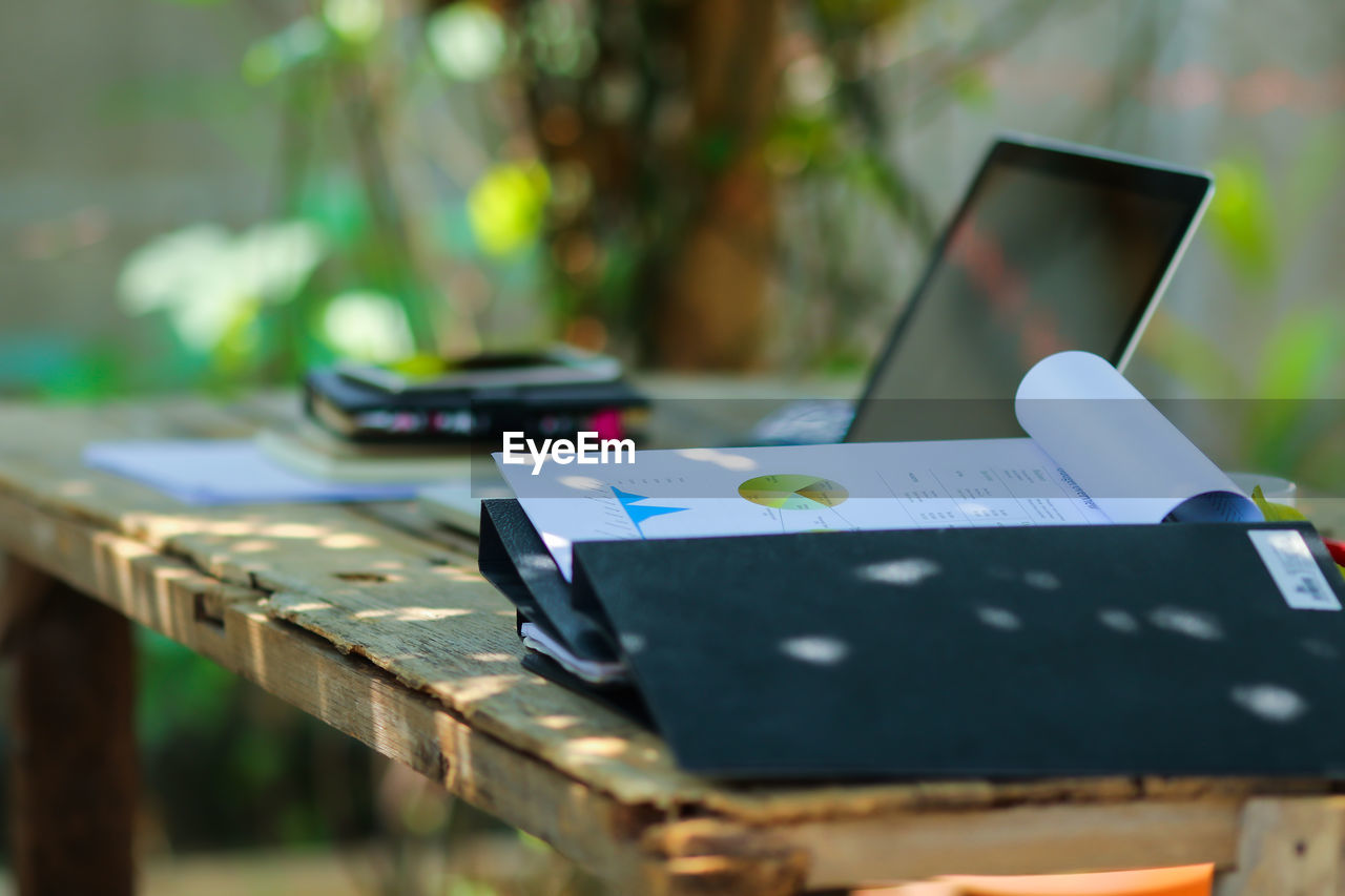 Close-up of files and laptop on table