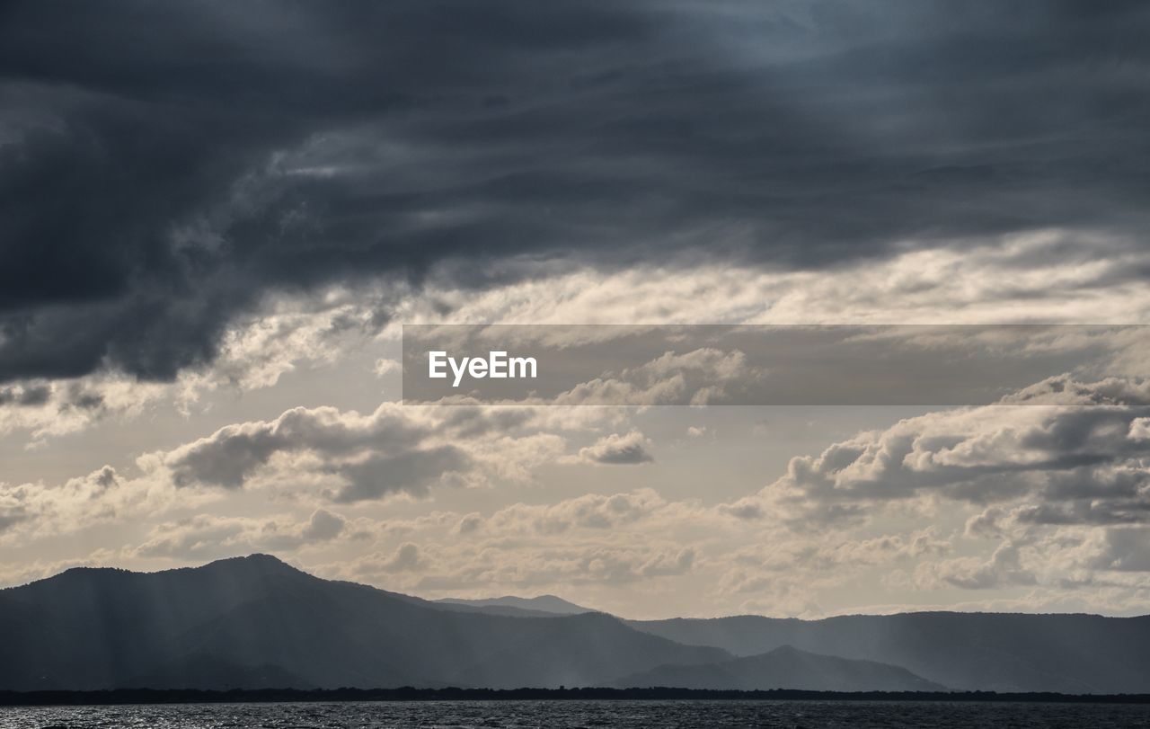 Scenic view of clouds over mountains against sky