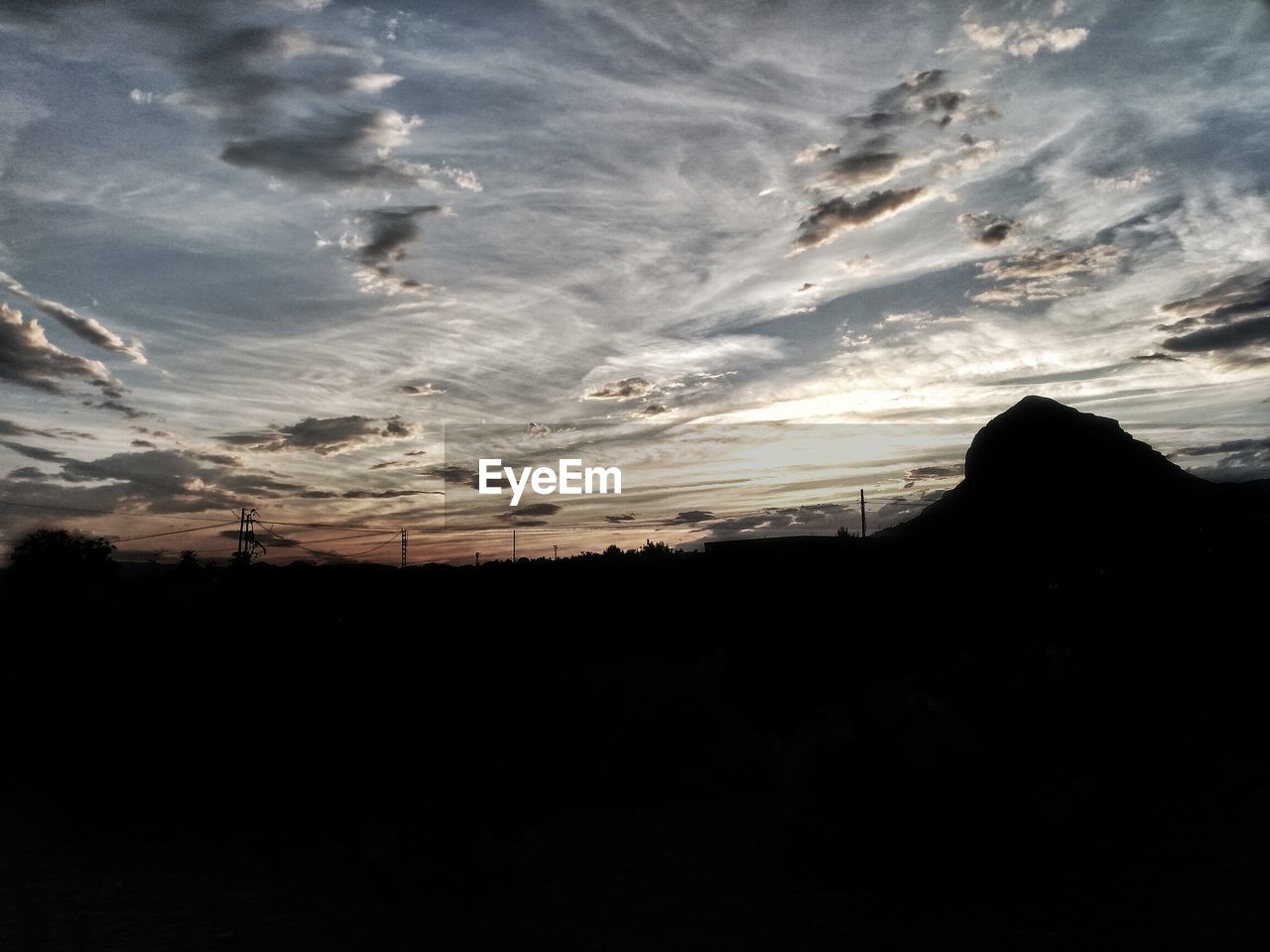 SCENIC VIEW OF SILHOUETTE LANDSCAPE AGAINST SKY AT SUNSET