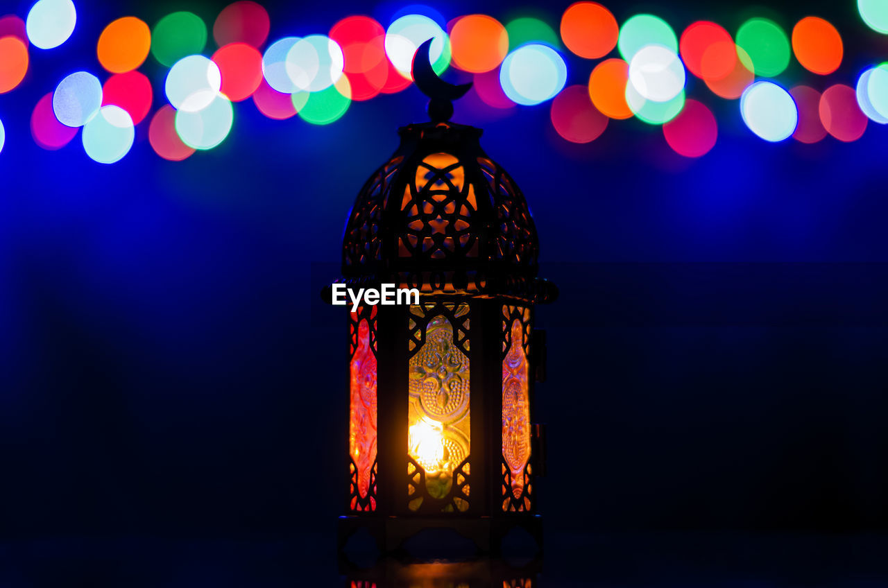 Lantern with colorful bokeh lights for islamic new year and ramadan kareem concept.