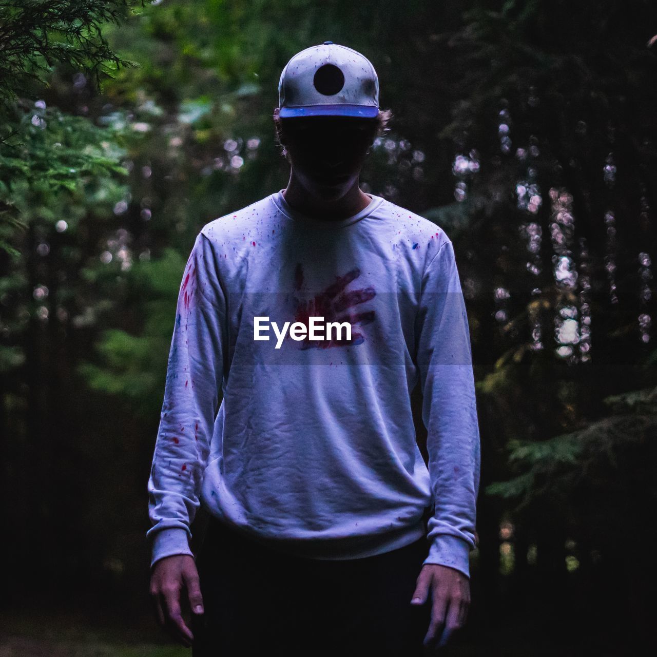 Man wearing cap standing in forest