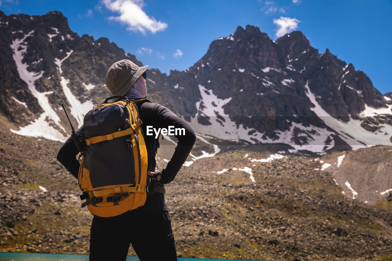 Tourist girl walking with backpacks in the mountains. hiking concept. back view of female hiker with