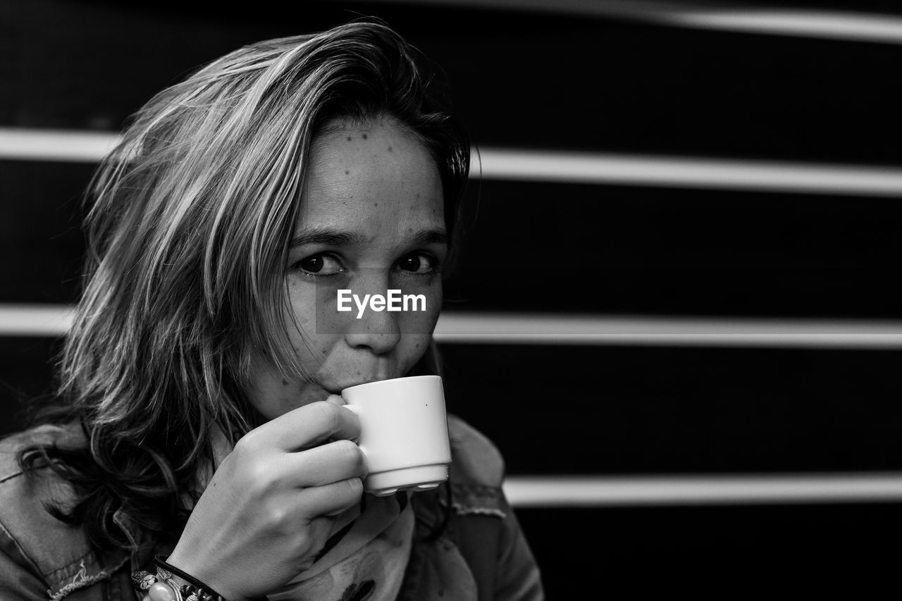 Portrait of woman drinking coffee at cafe
