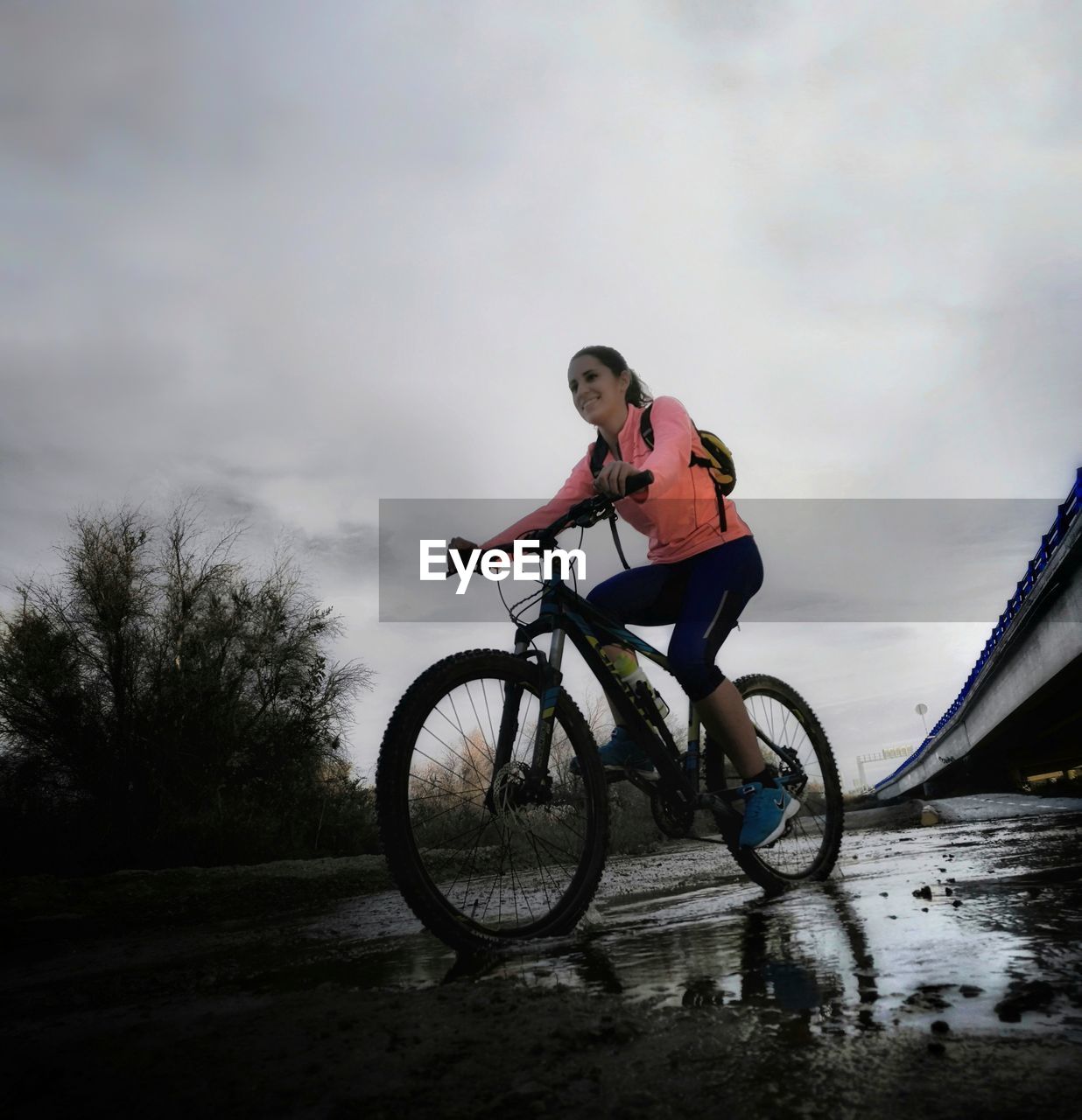 MAN RIDING BICYCLE IN PUDDLE