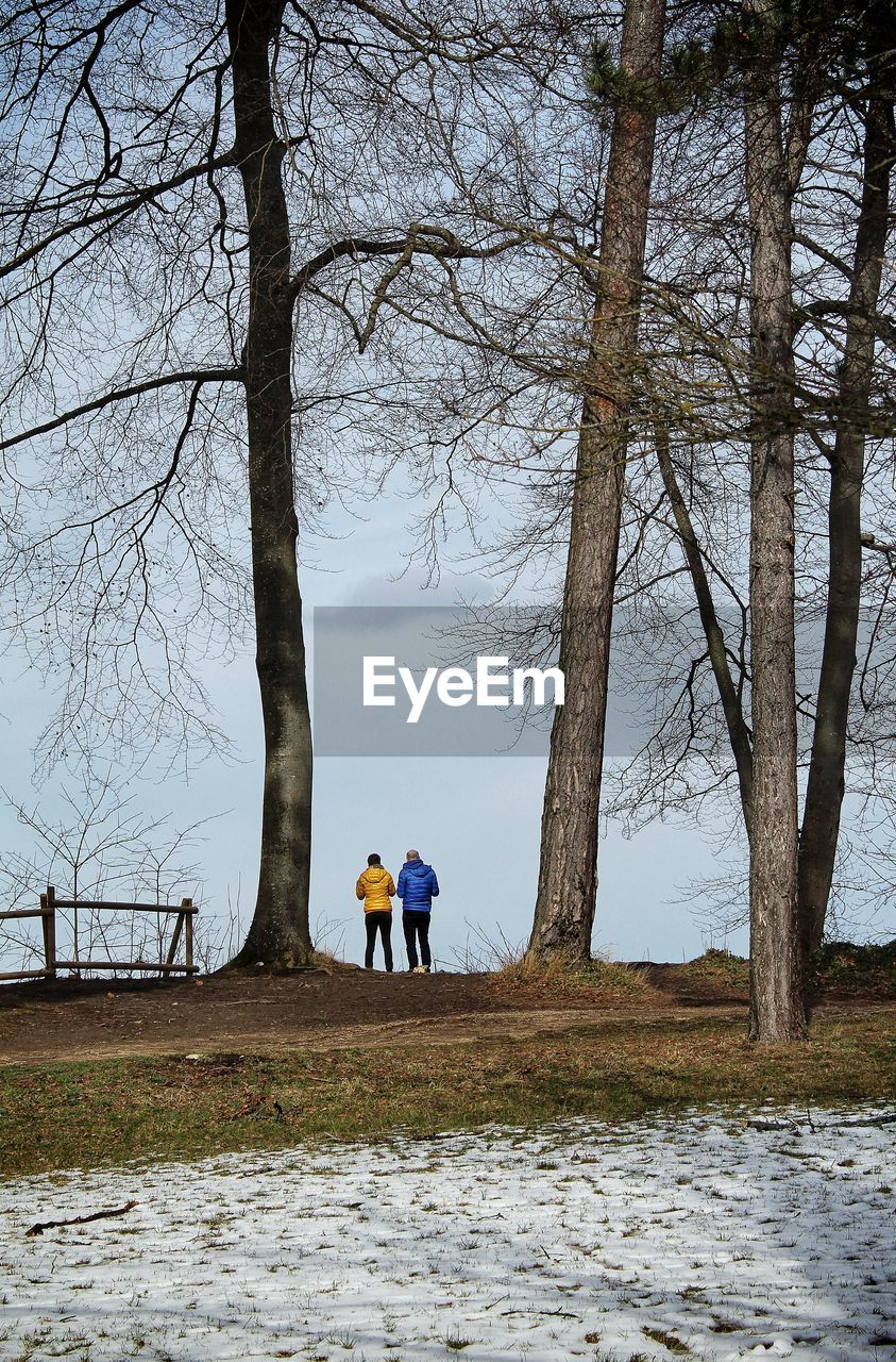 REAR VIEW OF MEN ON FIELD