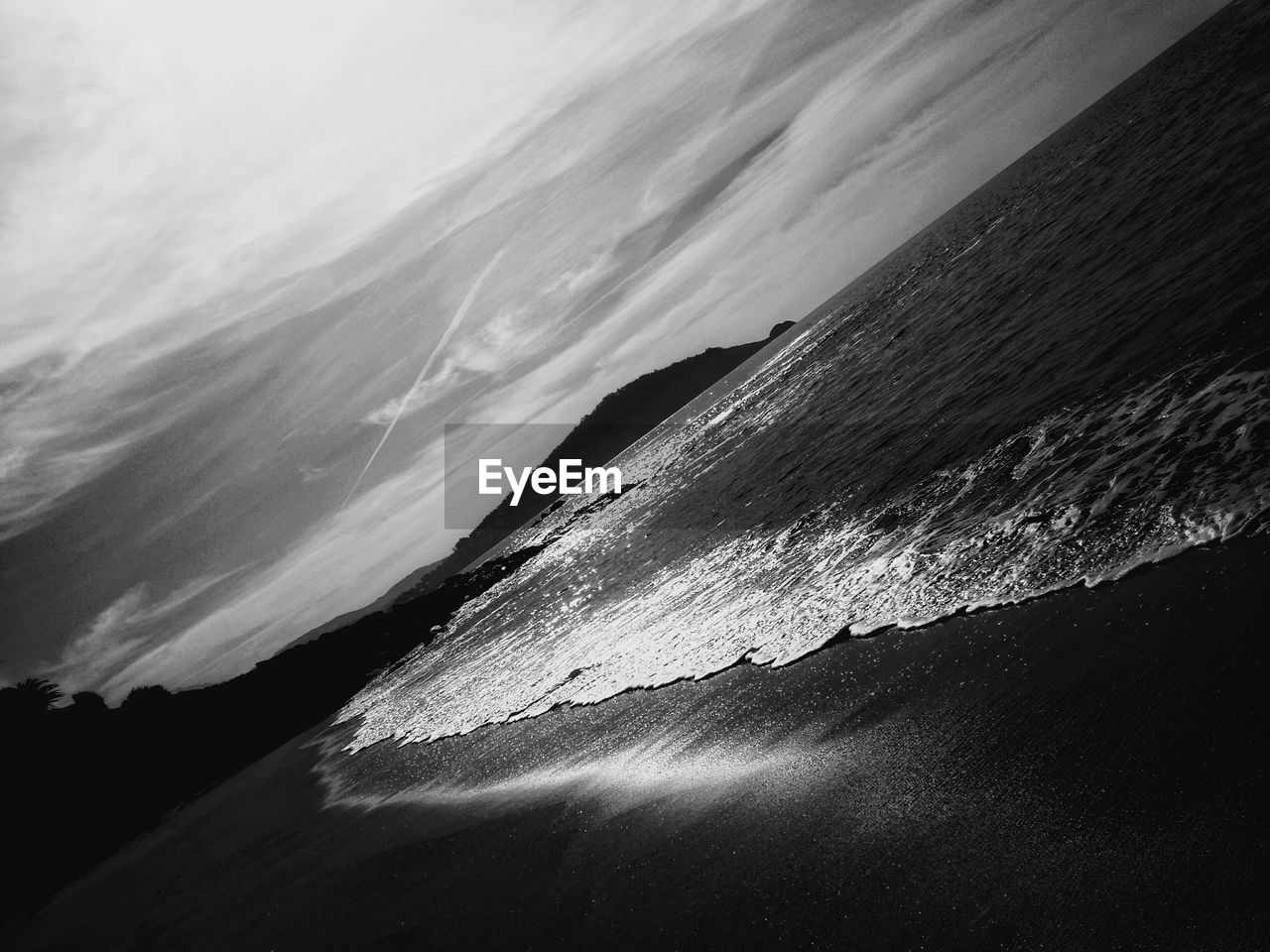 Scenic view of beach against cloudy sky