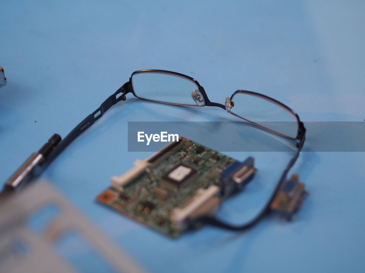 High angle view of eyeglasses and motherboard on table