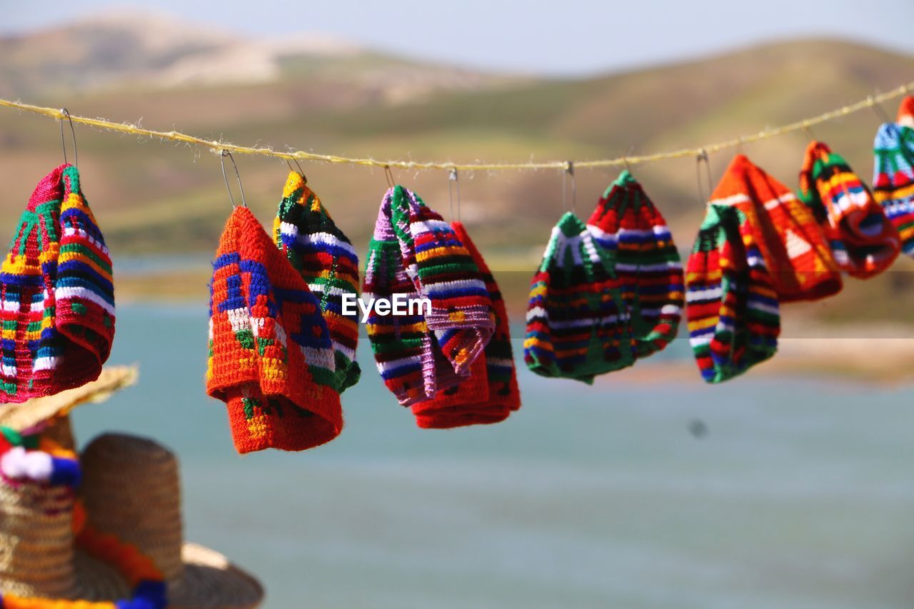 Close-up of multi colored hats hanging against sky in middle eastern