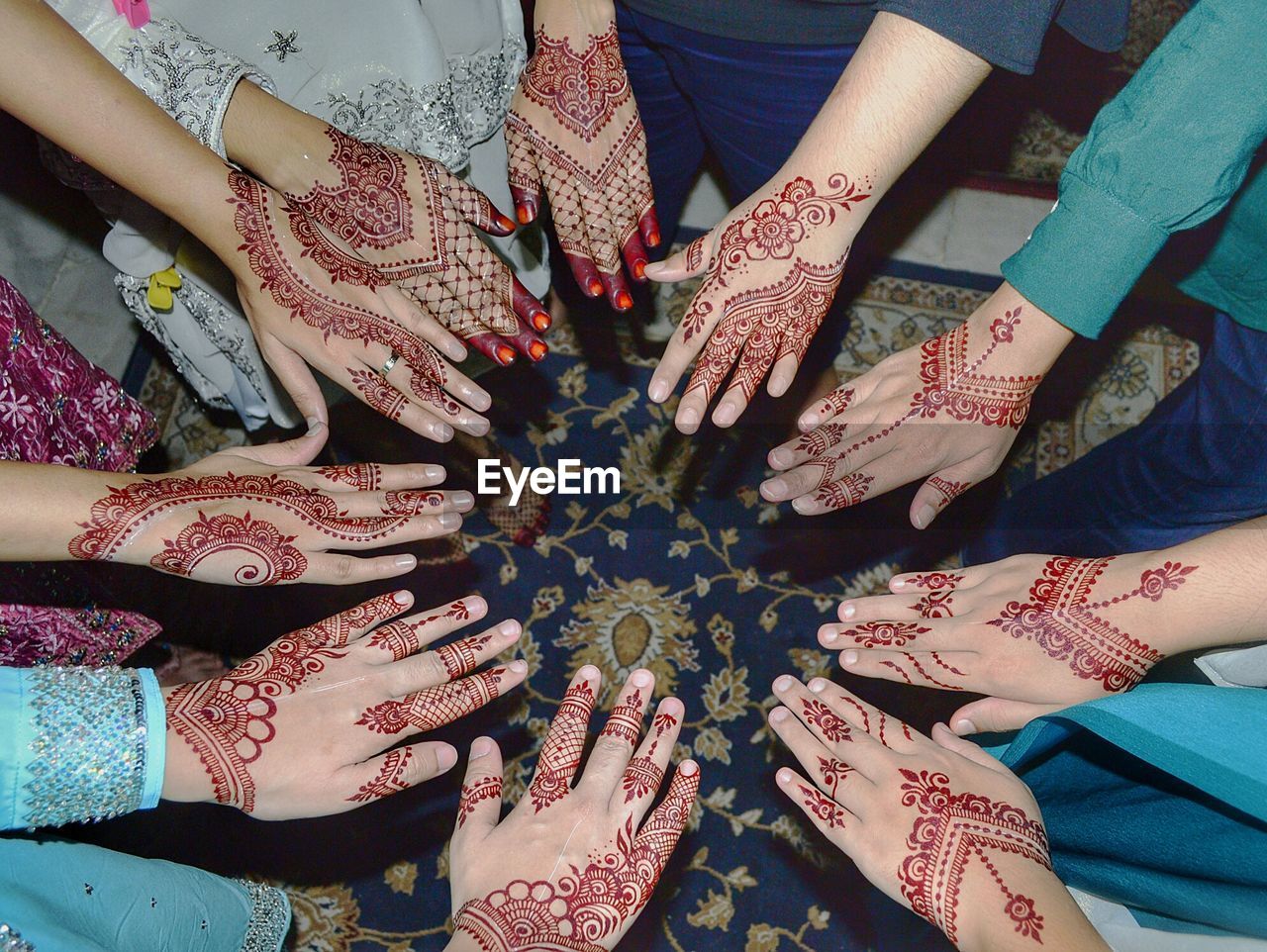 High angle view of female friends showing henna tattoos at home