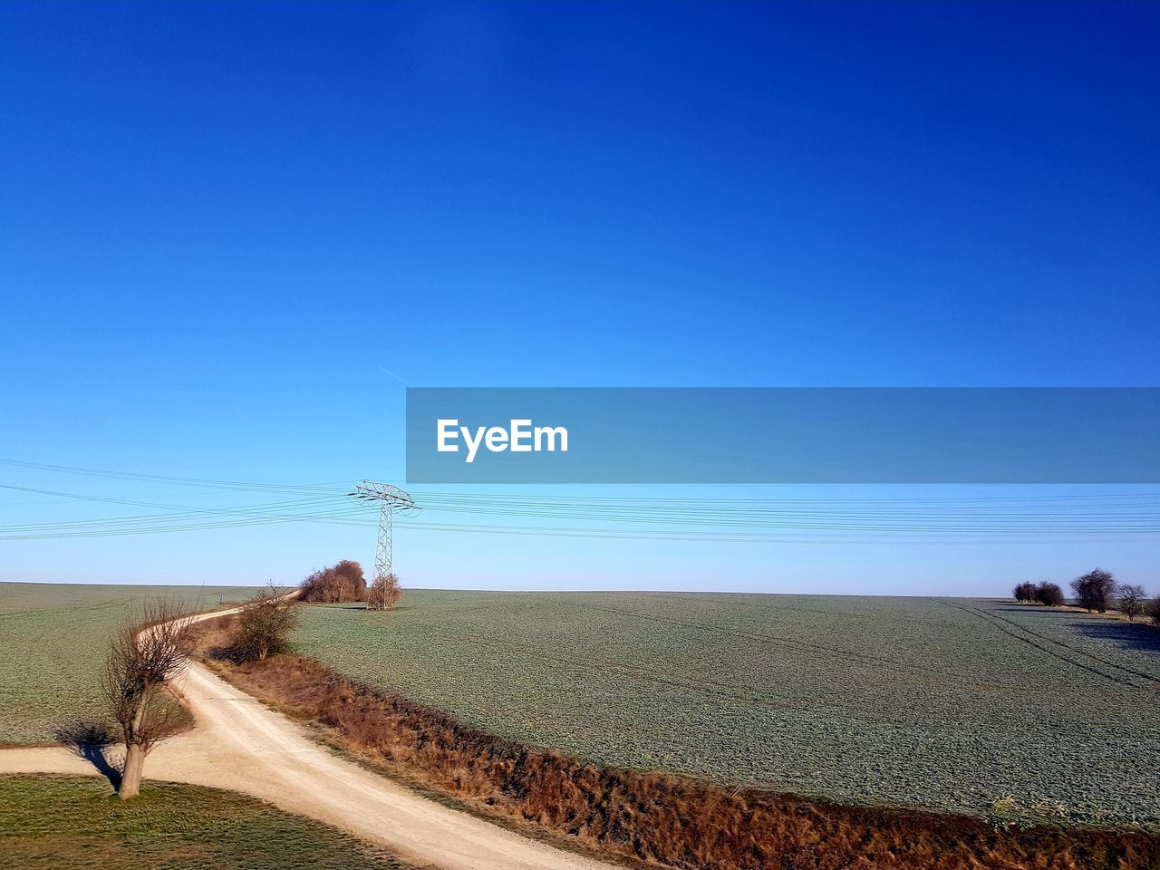SCENIC VIEW OF AGRICULTURAL LANDSCAPE AGAINST CLEAR BLUE SKY