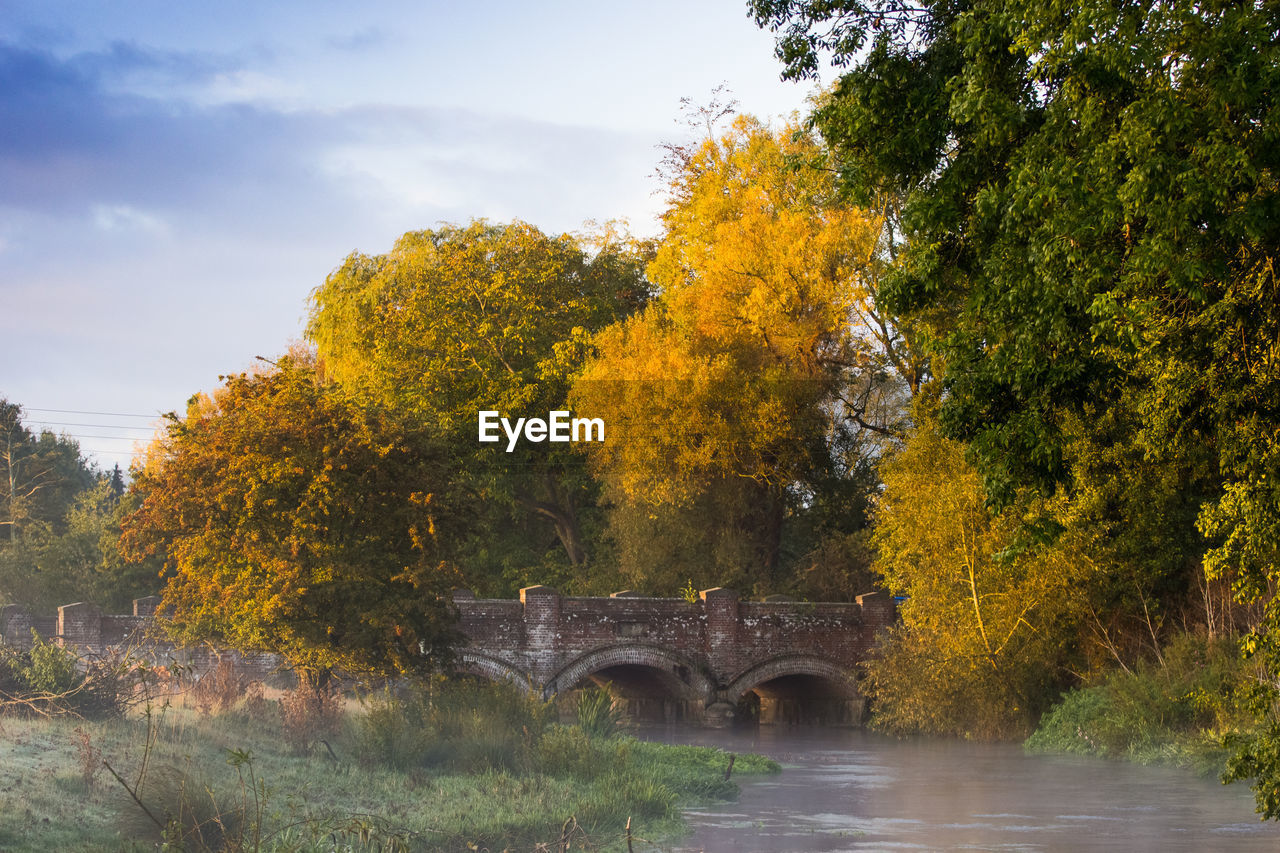 ARCH BRIDGE OVER RIVER DURING AUTUMN