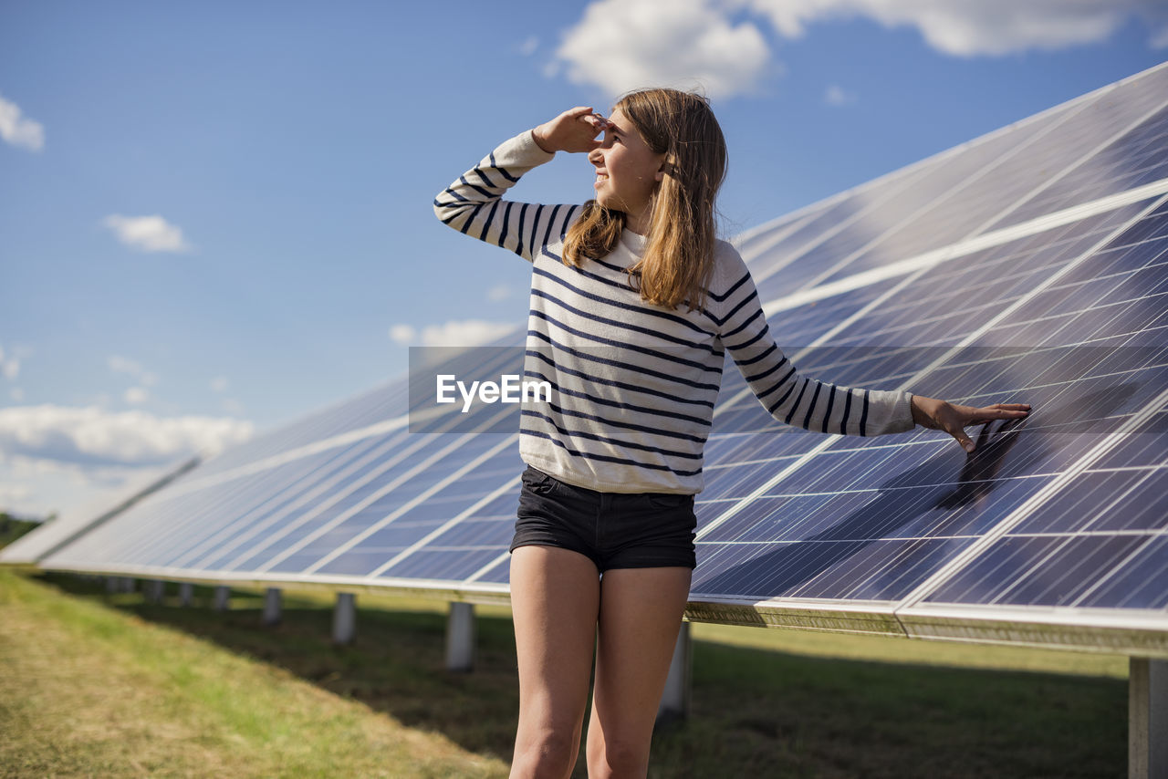 Girl standing next to solar panels