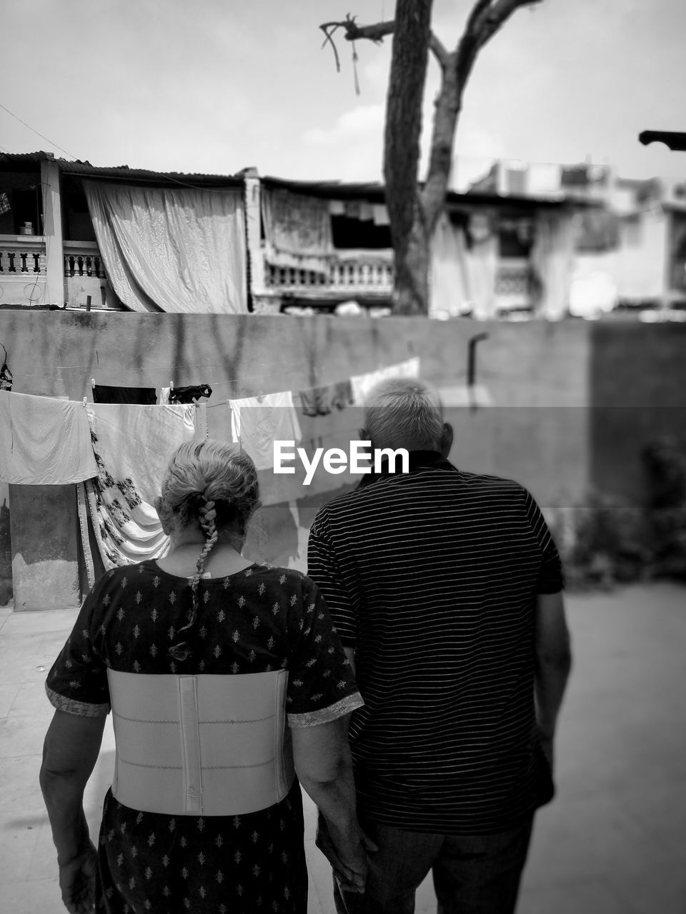 Rear view of senior couple walking in city