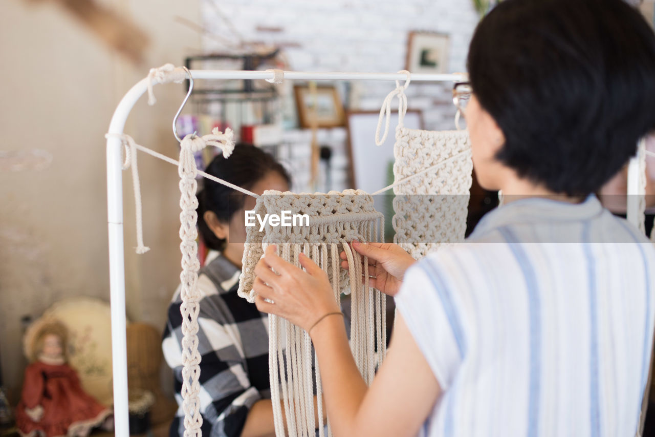 Rear view of woman making decoration at store