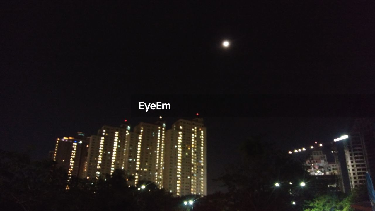 ILLUMINATED BUILDINGS AGAINST SKY AT NIGHT