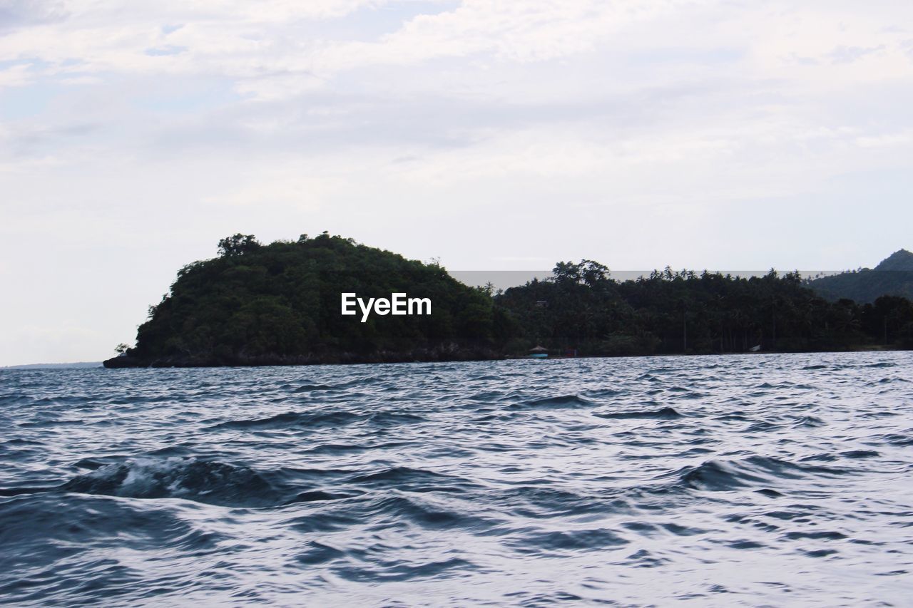 VIEW OF CALM SEA AGAINST MOUNTAIN