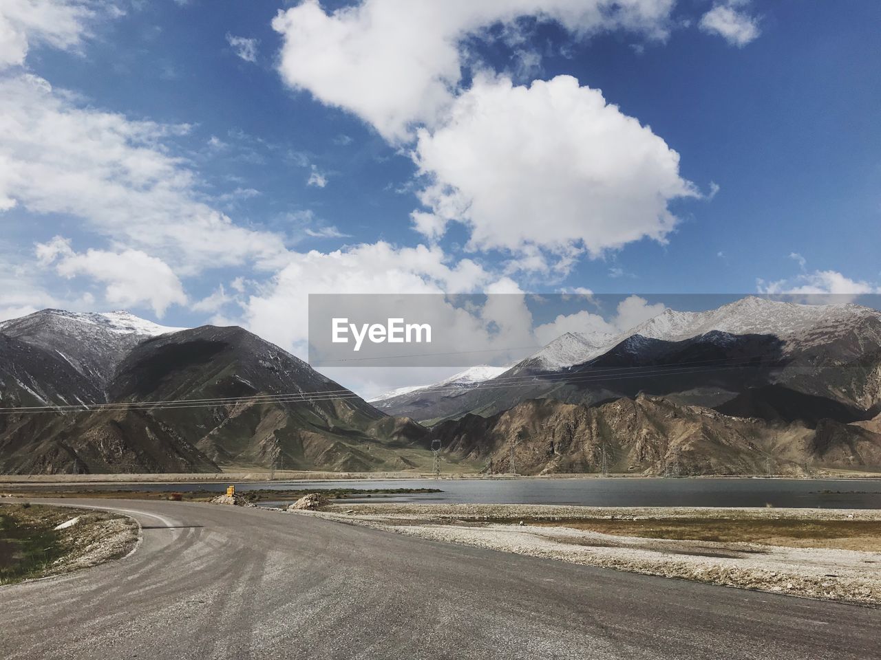 Road by mountains against sky