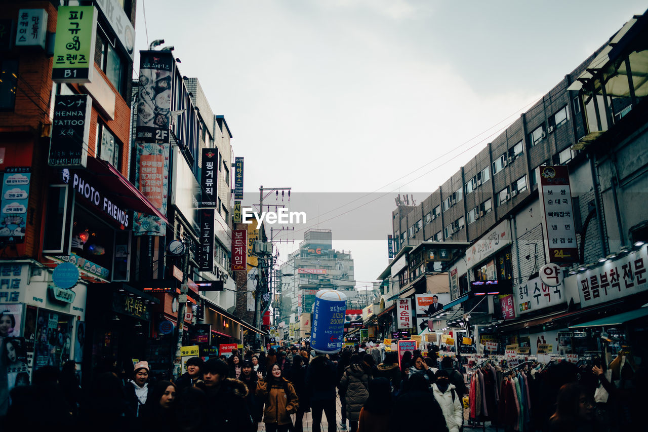 GROUP OF PEOPLE WALKING ON STREET IN CITY