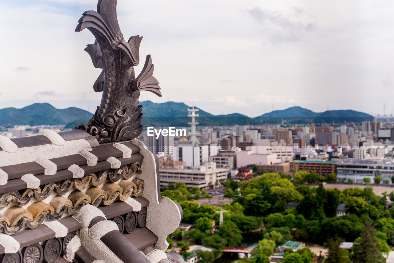 STATUE OF BUILDINGS AGAINST CLOUDY SKY