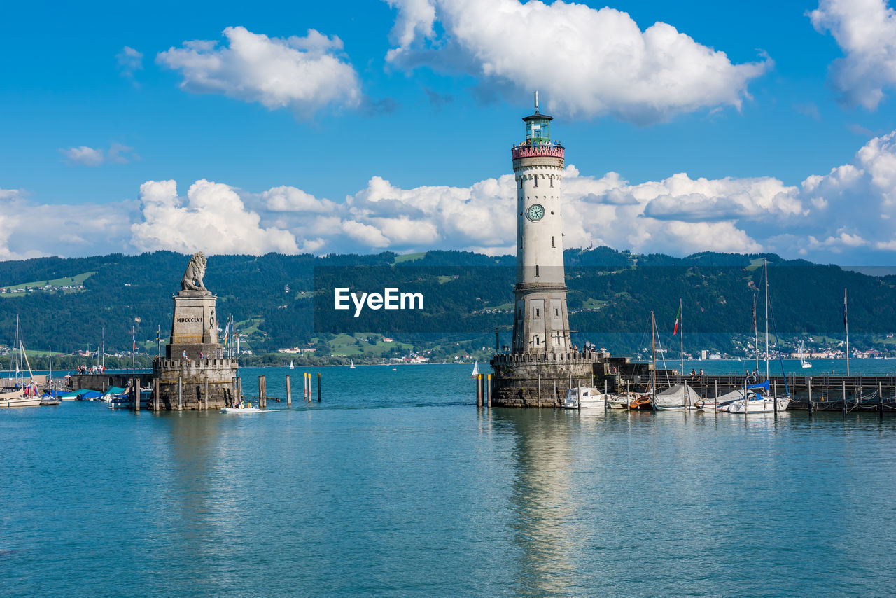 LIGHTHOUSE BY SEA AGAINST SKY AND BUILDINGS