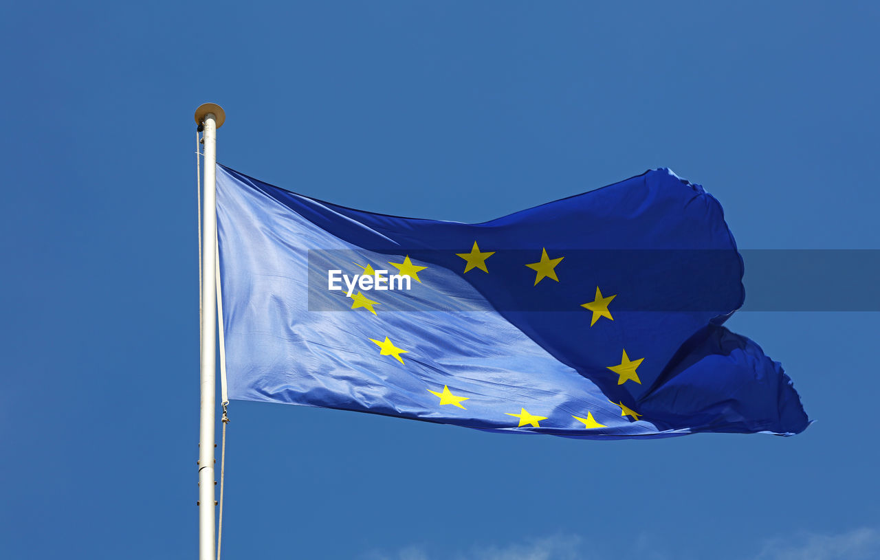 Low angle view of european union flag against blue sky