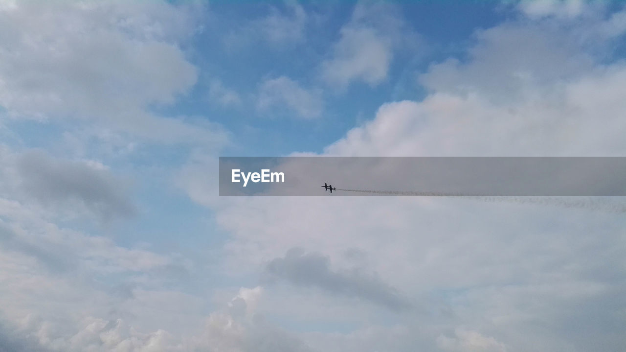 Low angle view of airplane flying against sky