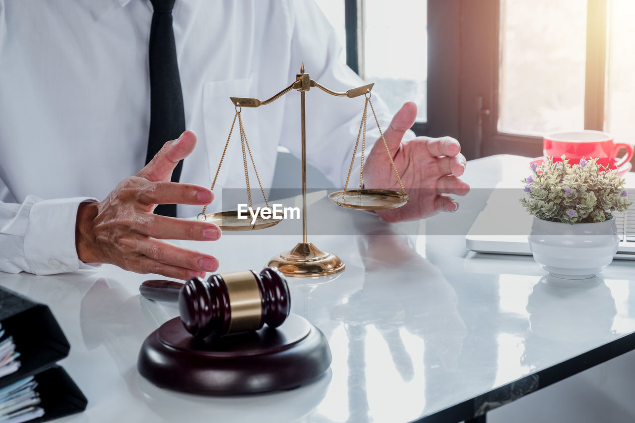 CLOSE-UP OF PEOPLE ON TABLE BY POTTED PLANTS