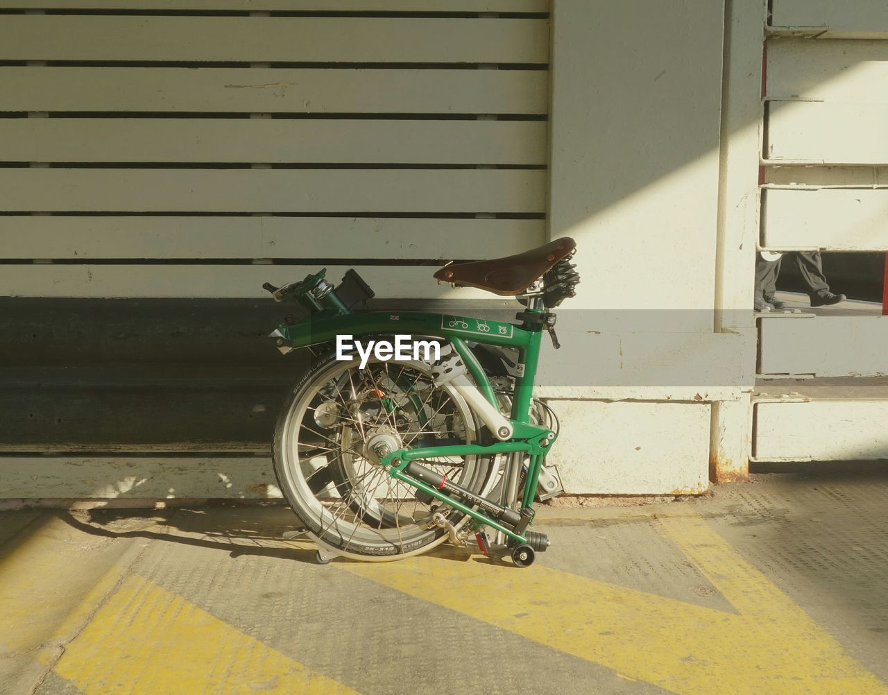 Bicycle parked on street by wall