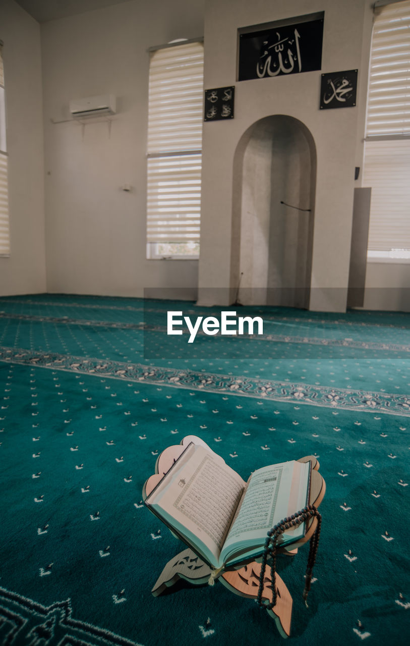 EMPTY CHAIR BY SWIMMING POOL IN BUILDING