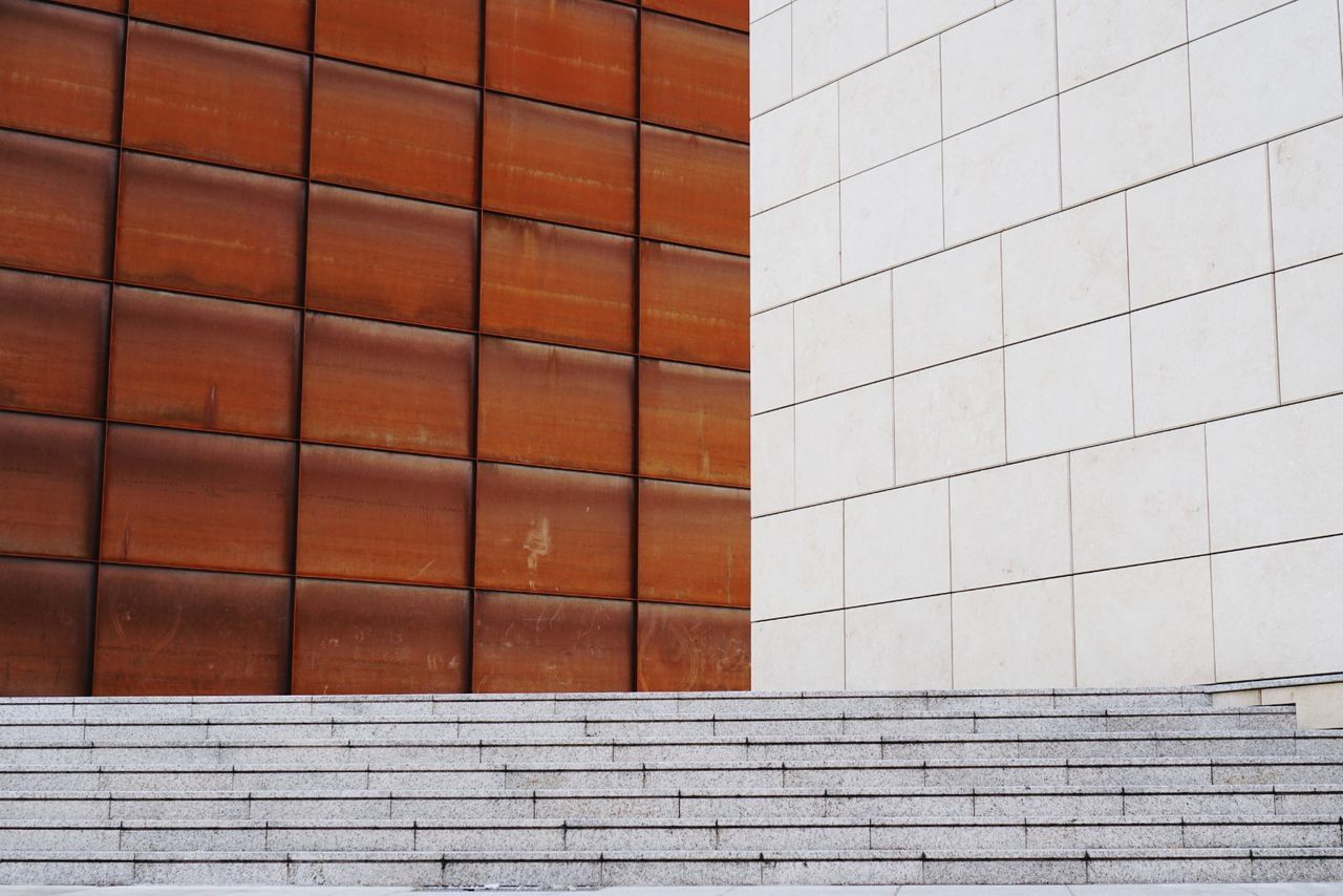 FULL FRAME SHOT OF BRICK WALL WITH BUILDING