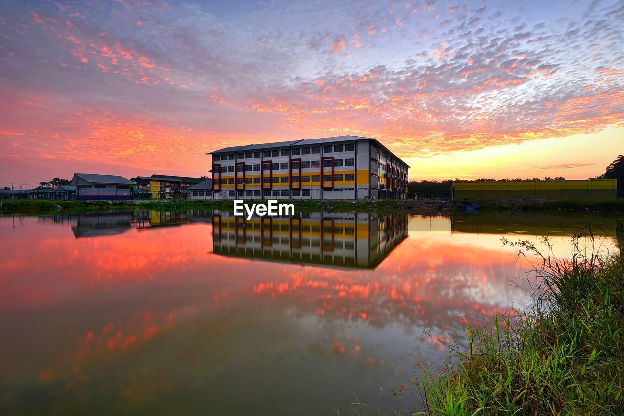 Reflection of cityscape in river at sunset