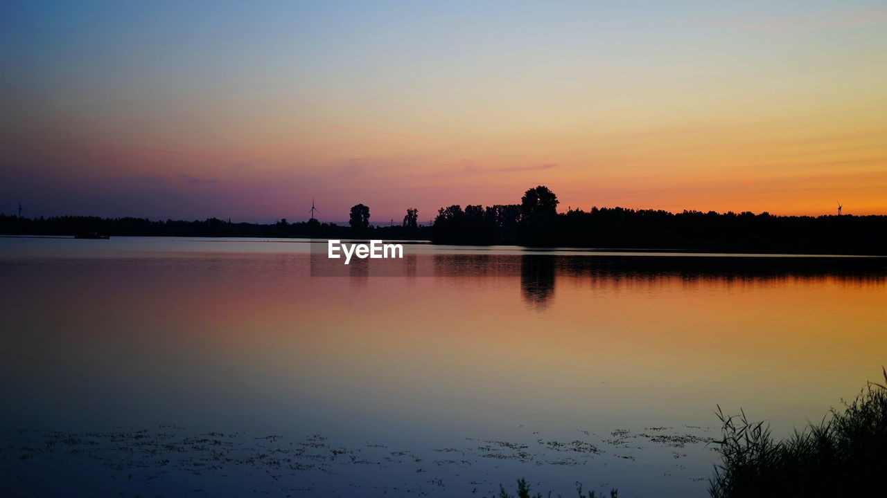 SCENIC VIEW OF LAKE AGAINST SKY DURING SUNSET