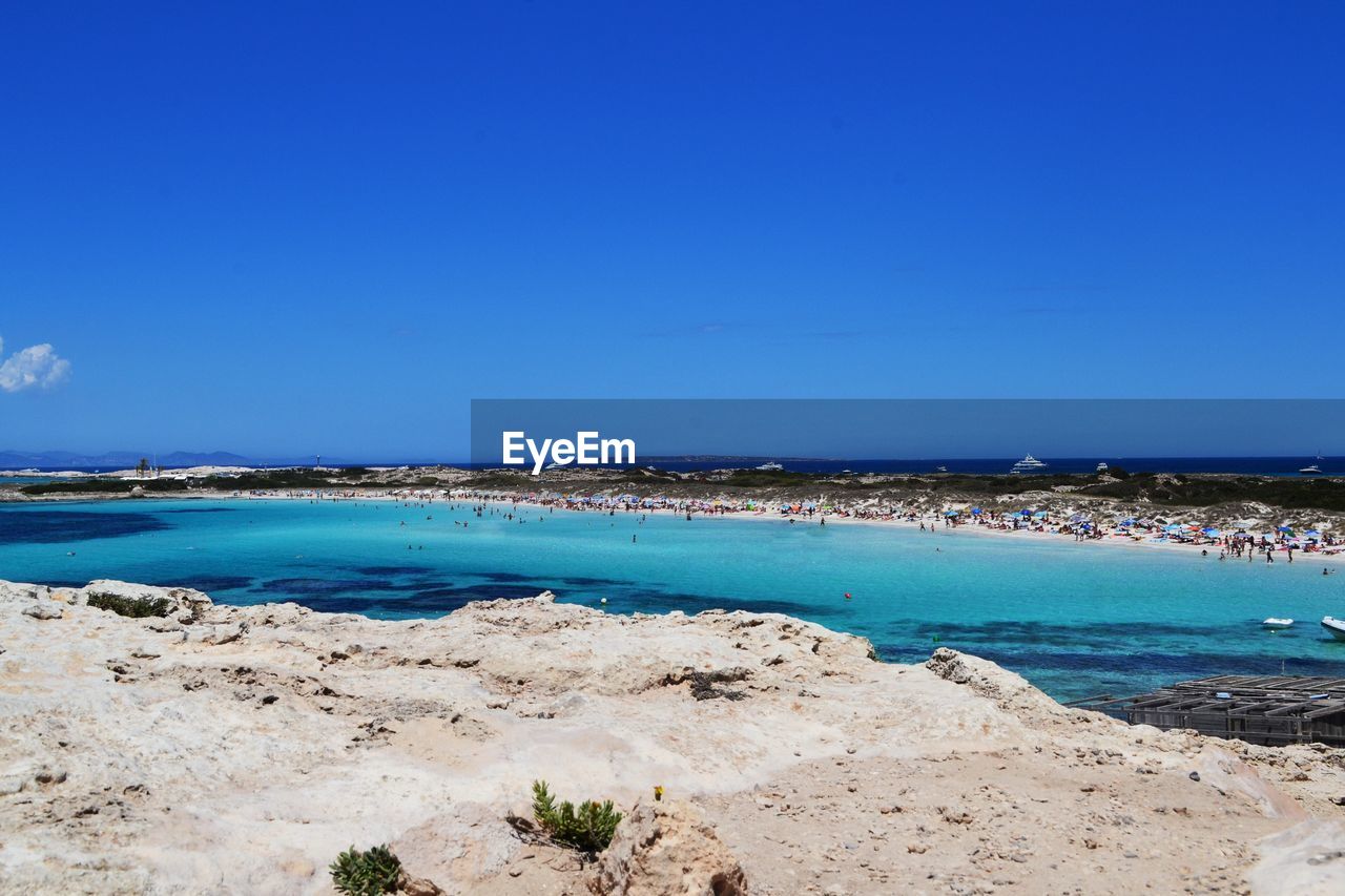 Scenic view of beach against clear blue sky