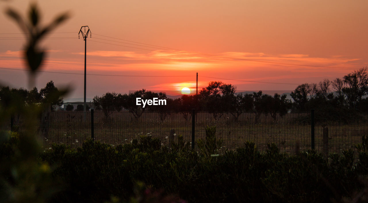 SCENIC VIEW OF SILHOUETTE FIELD AGAINST SKY DURING SUNSET