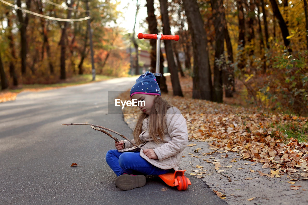 Man sitting on street during autumn