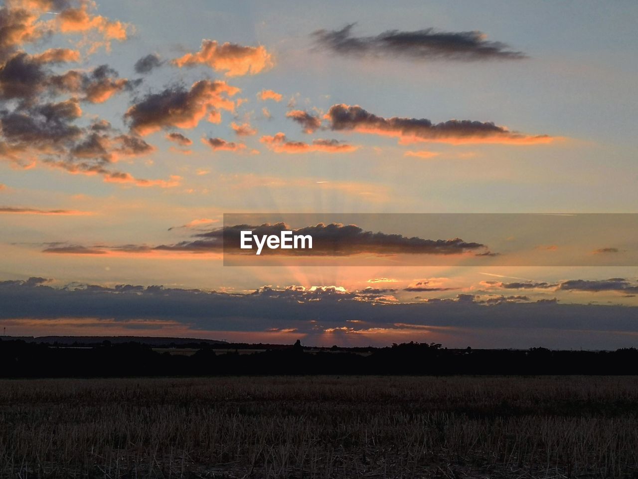 SCENIC VIEW OF SUNSET OVER FIELD