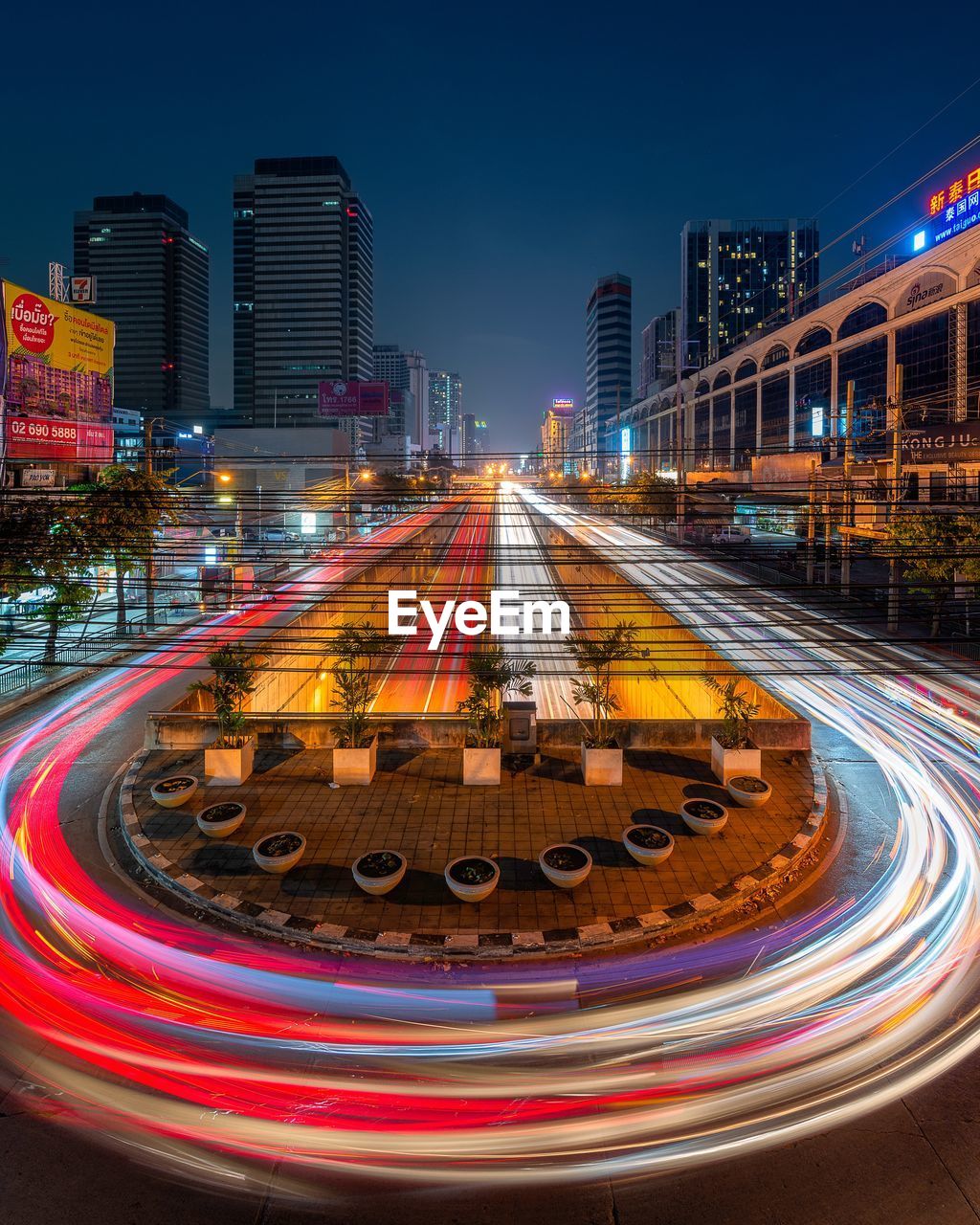 Light trails on road amidst buildings in city at night