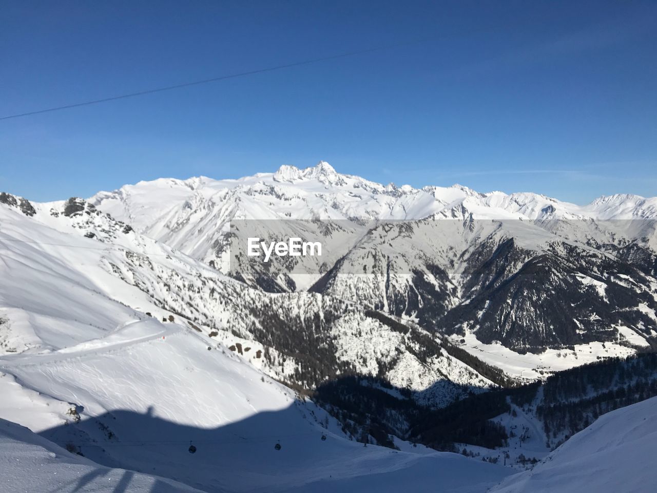 Scenic view of snowcapped mountains against clear blue sky