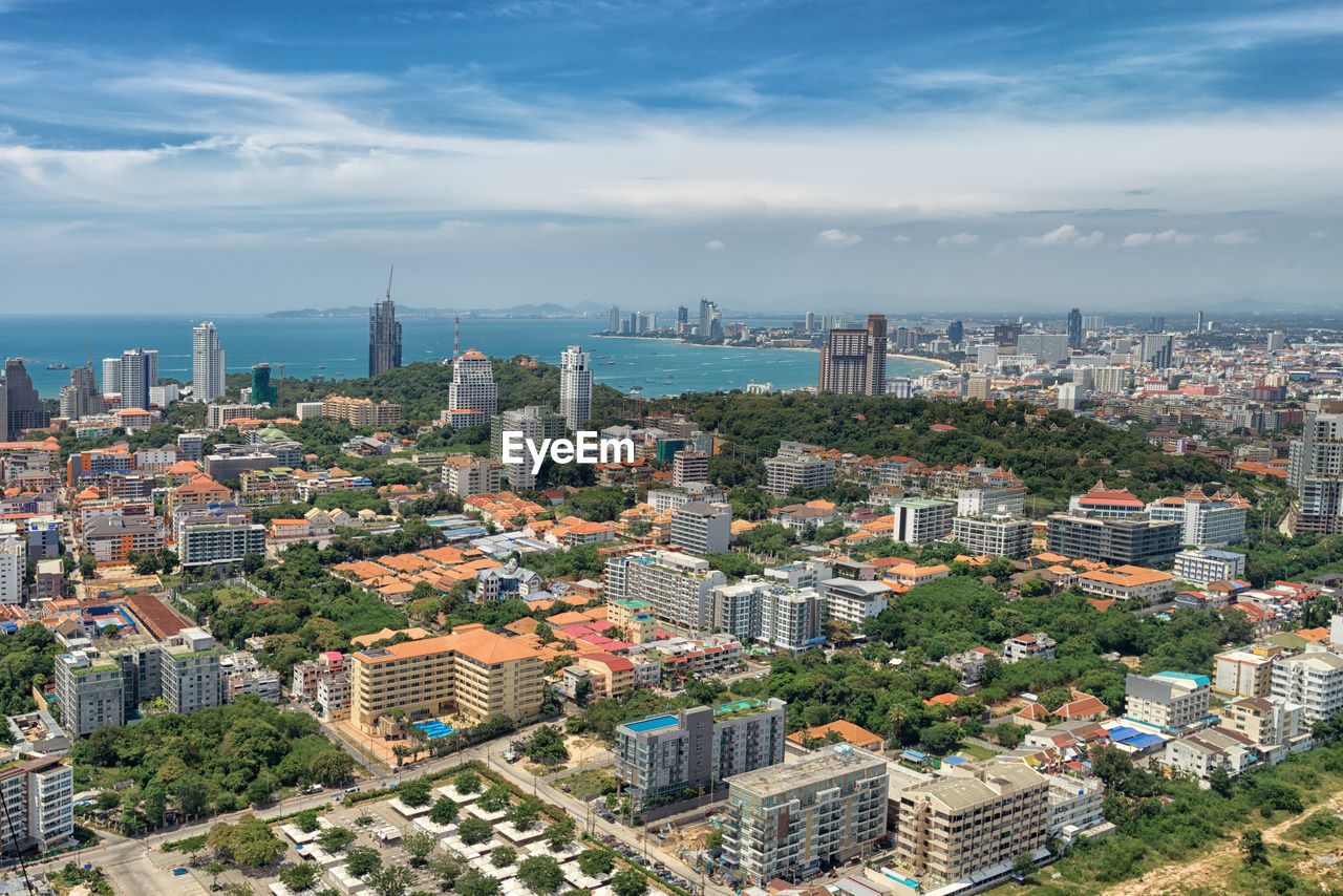 High angle view of city by sea against sky