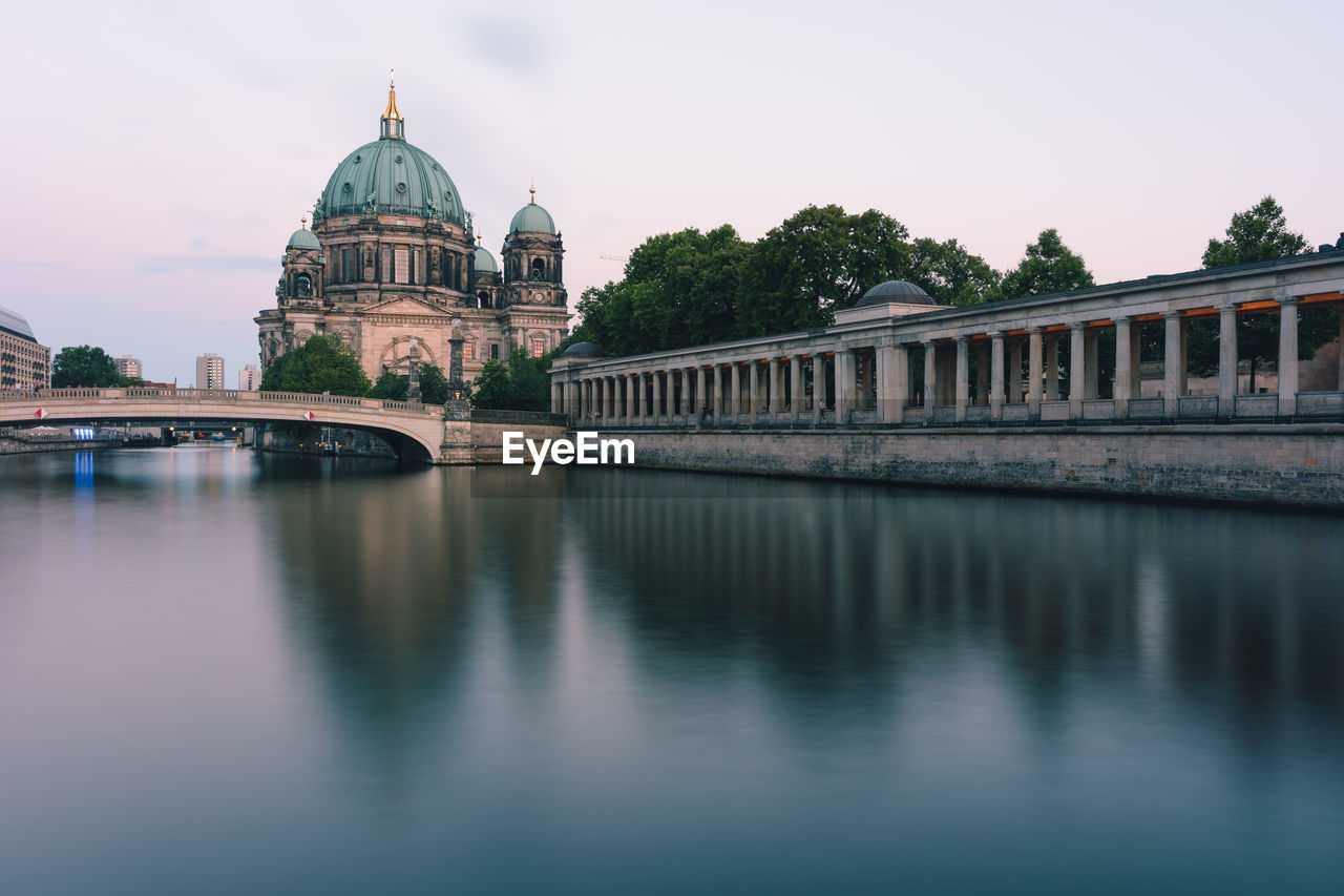 Arch bridge over river against buildings